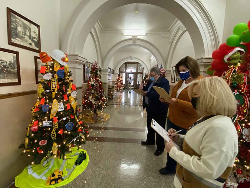From back, Tommy Fallin, Debbie Arnold and Micki Mitchell judge the Christmas trees during the Columbia County Judge’s Christmas Tree Competition.