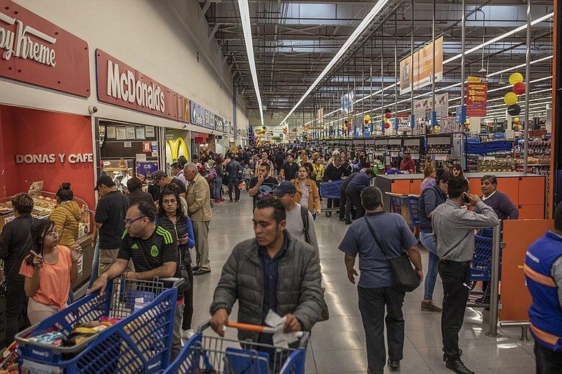 Shoppers walk through a Walmart de Mexico SAB store during Buen Fin in Mexico City, Mexico, on Saturday, Nov. 16, 2019. Buen Fin seeks to revive the economy by encouraging consumption by offering consumers discounts throughout the country for four days. Photographer: Alejandro Cegarra/Bloomberg