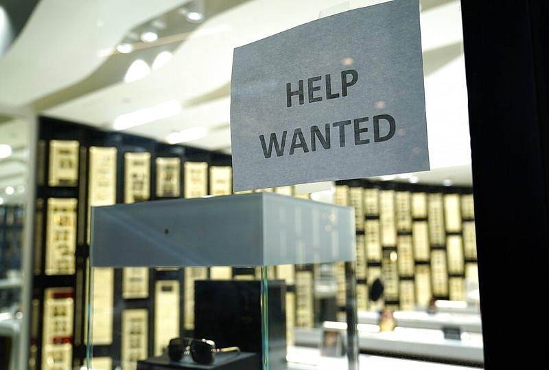 A Help Wanted sign is posted at a Designer Eyes store at Brickell City Centre, Friday, Nov. 6, 2020, in Miami.