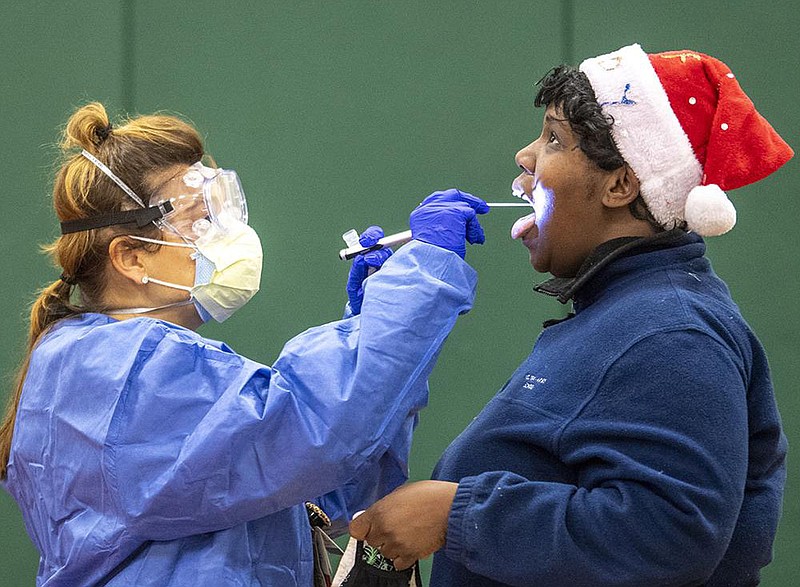 Jaqueline Koren, a registered nurse in Camden, N.J., gives a coronavirus test Wednesday to a woman at the Cooper’s Poynt School. The city has opened new testing sites because of a recent surge in coronavirus cases.
(AP/The Philadelphia Inquirer/Jose F. Moreno)