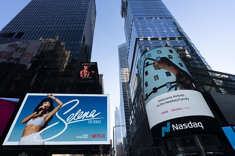 The listing for Airbnb appears Thursday on an electronic screen (right) at the Nasdaq Market Site in New York. The initial public offering for the San Francisco-based online vacation rental company was Thursday.
(AP/Mark Lennihan)