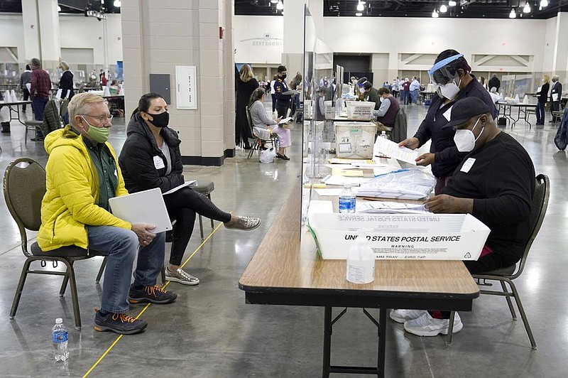 Election workers verify ballots in this Nov. 20 photo as recount observers watch during a Milwaukee hand recount of presidential votes. A federal judge Thursday cast doubt on a lawsuit by President Donald Trump seeking to overturn the results of the state’s presidential election.
(AP/Nam Y. Huh File)