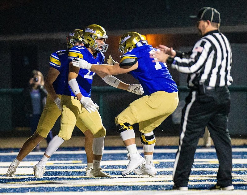 Cam Wiedemann (center) of Shiloh Christian celebrates with teammates after scoring the Saints’ first touchdown in a 56-7 victory over Stuttgart in a Class 4A state semifinal on Friday at Champion Stadium in Springdale.
(Special to the NWA Democrat-Gazette/David Beach)