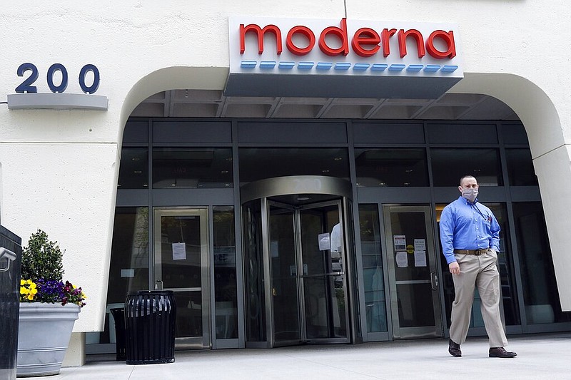 FILE - A man stands outside an entrance to a Moderna, Inc., building, Monday, May 18, 2020, in Cambridge, Mass.