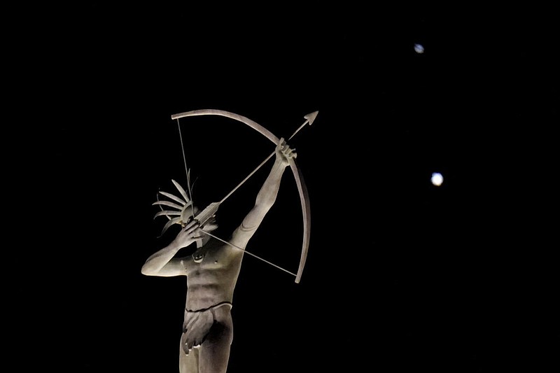 A statue of a Kansa Indian stands atop the Kansas Statehouse in Topeka as Saturn (top) and Jupiter (below) are seen Saturday, Dec. 19, 2020. The two planets are drawing closer to each other in the sky as they head toward a "great conjunction" on Monday, Dec. 21, where the two giant planets will appear a tenth of a degree apart.