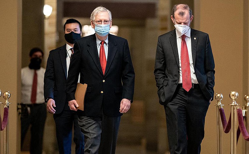 Senate Majority Leader Mitch McConnell (center) walks Friday with a member of his staff to the Senate chamber at the U.S. Capitol.
(The New York Times/Anna Moneymaker)