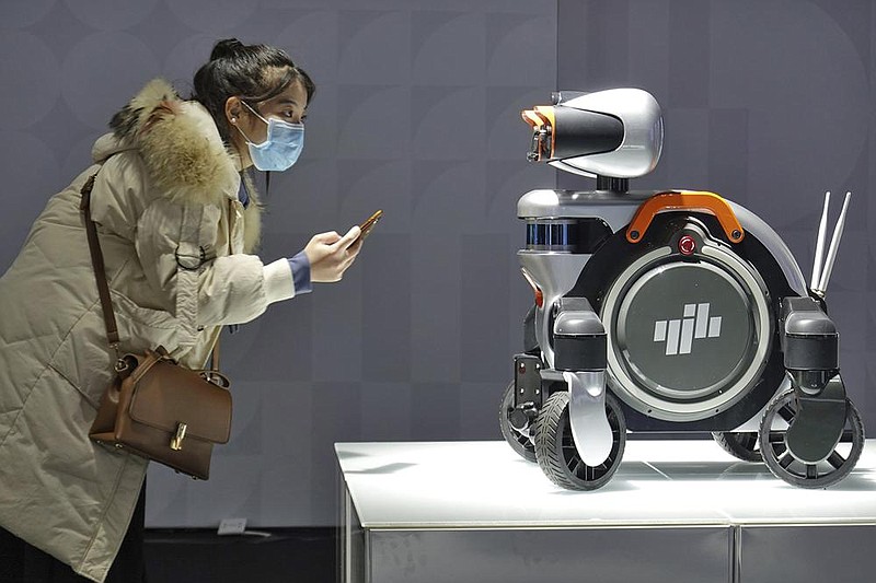 A woman checks out a model of a patrol robot at the World Industrial Design Conference in Yantai in eastern China’s Shandong Province in late November. The ruling Communist Party on Friday called for faster technology development to increase China’s economic independence amid tension with Washington that has disrupted access to computer chips and other high-tech components.
(AP file photo)