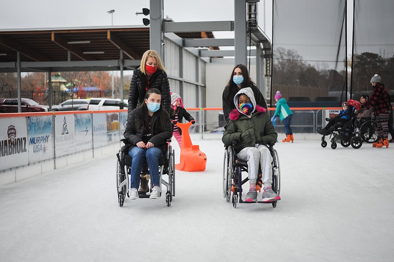 Kristi Lowery, right, president and CEO of HOPE Landing, skates on the ice with Madison Livingston, left, alumna of HOPE and organizer of the skate parties. (Contributed)