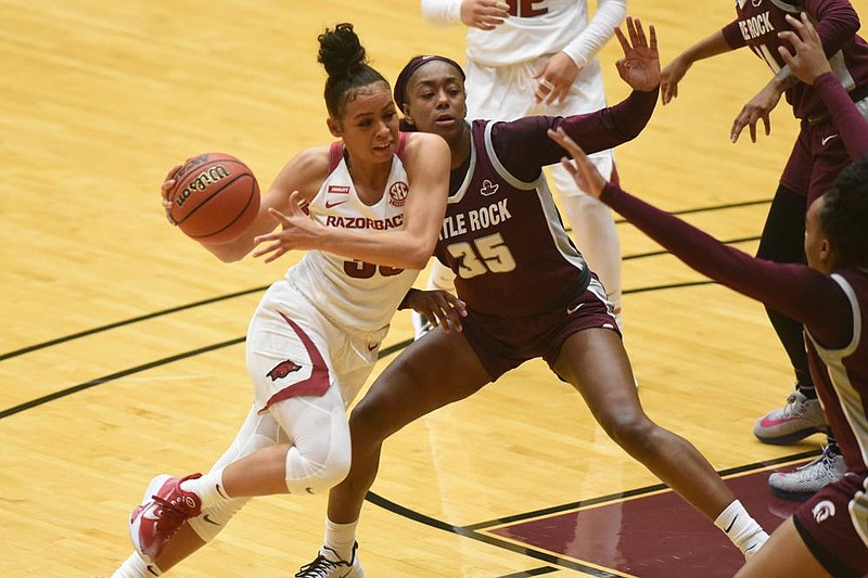 University of Arkansasâ€™s Chelsea Dungee (33) moves the ball around University of Arkansas at Little Rockâ€™s Teal Battle (35) during the first half of Saturdayâ€™s game at the Jack Stephens Center in Little Rock. More photos at arkansasonline.com/1220trojanrazor/.(Arkansas Democrat-Gazette/Staci Vandagriff)