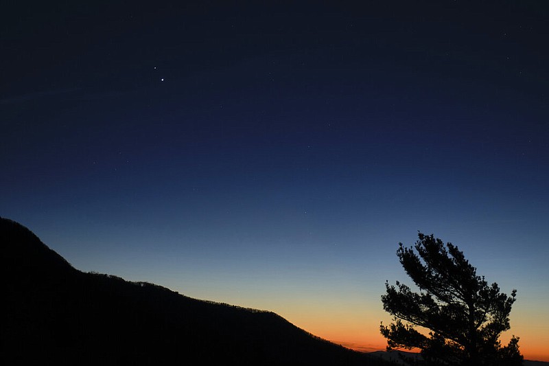 In this Sunday, Dec. 13, 2020 photo made available by NASA, Saturn, top, and Jupiter, below, are seen after sunset from Shenandoah National Park in Luray, Va.