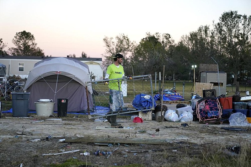 Ricky Trahan moves debris Dec. 4 at his home, which was destroyed in two hurricanes earlier this year in Lake Charles, La. Trahan and his wife currently live in a tent.
(AP/Gerald Herbert)