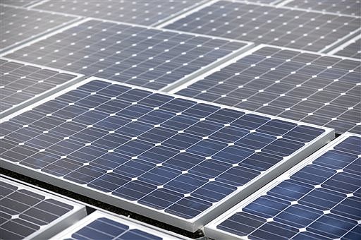 Solar cells are installed on the flat roof of a building in Decatur, Ga., in this Sept. 26, 2013, file photo.