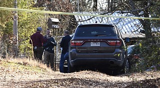 Investigators talk with each other Saturday, Dec. 26, 2020, outside the home in Atkins where five people were found dead Christmas Day.
