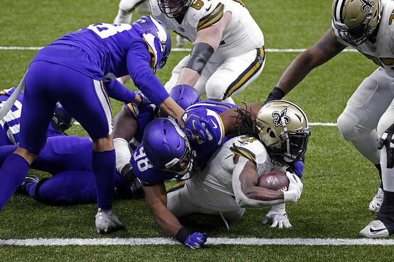 Alvin Kamara (shown with ball) scores his sixth touchdown of the day, tying the NFL record for most rushing touchdowns in a game, to help the New Orleans Saints beat the Minnesota Vikings 52-33 on Friday in New Orleans. Kamara ran for a career-high 155 yards as the Saints clinched a fourth consecutive NFC South title. More photos at arkansasonline.com/1226saints/
(AP/Butch Dill)