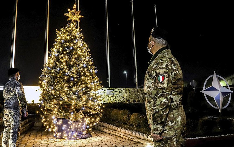 Italian soldiers serving with the NATO peacekeeping mission in  Kosovo take a moment to admire a Christmas tree at the force’s  headquarters in Pristina, the Kosovo capital. 
(AP/KFOR)