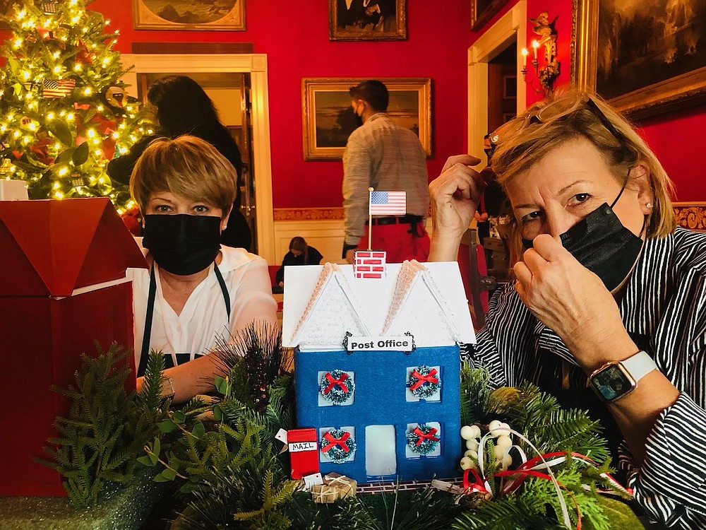 Julie Walters from South Carolina, left, sits with Liz Bullock, right, as they decorate the Red Room in the White House. This year the room was decorated to honor first responders and essential workers of 2020. (Contributed)