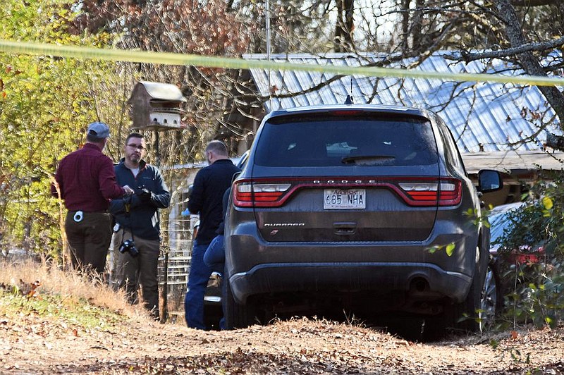 Investigators with the Pope County sheriff’s office and Arkansas State Police work Saturday at a home near Atkins where five people were found dead late Christmas Day. (Arkansas Democrat-Gazette/Staci Vandagriff)