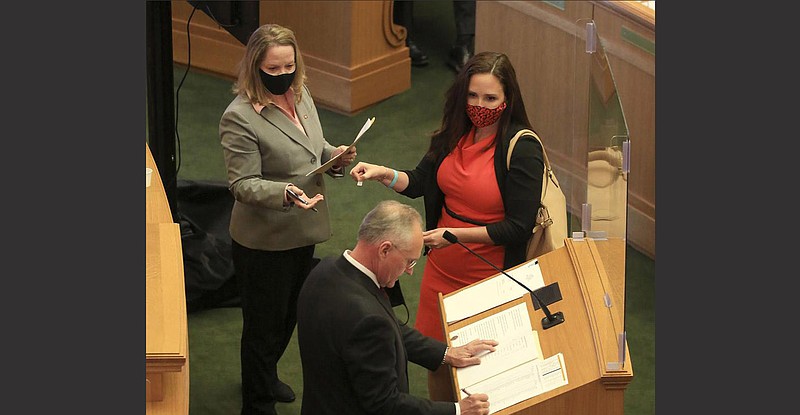 Rep.-elect Ashley Hudson (center), D-Little Rock, draws for seniority Dec. 2 from Kaye Donham, assistant to the state House of Representatives speaker, as House Parliamentarian Buddy Johnson notes the result during a House organizational meeting at the state Capitol.
(Arkansas Democrat-Gazette/Staton Breidenthal)