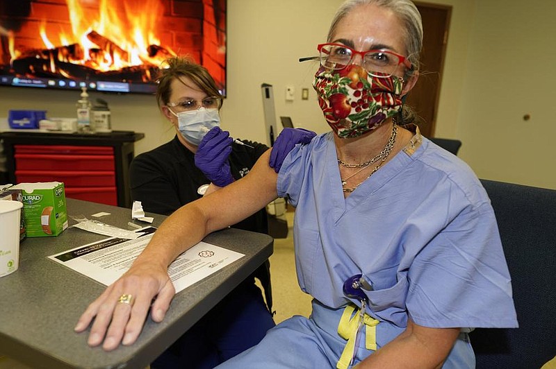 Rebecca Hong, a registered nurse and assistant nurse manager at Rose Medical Center in Denver, administers the covid-19 vaccine from Moderna to Dr. Kristi Keil, a urogynecologist at the hospital, on Wednesday. Many employers are providing vaccinations for workers, but aren’t requiring them.
(AP/David Zalubowski)