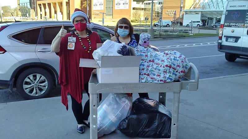 Sarah Payton (right), president of the Willing Workers of White Hall Extension Homemakers Club, delivers blankets to UAMS Volunteer Services Coordinator Marcia Dunbar earlier this month in Little Rock. 
(Special to The Commercial)