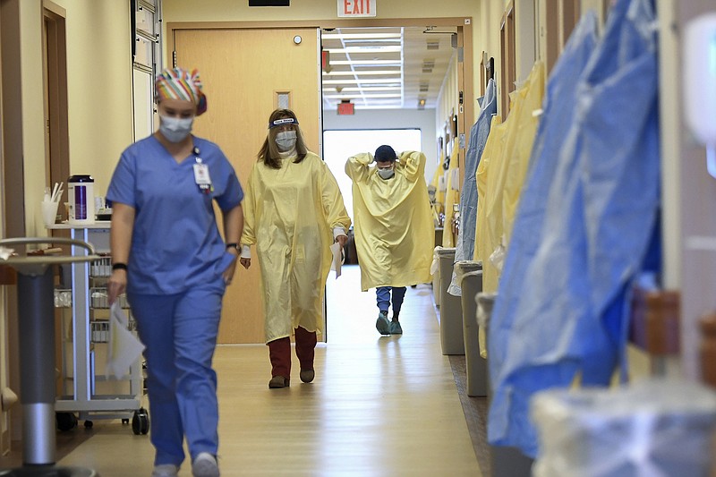 Nurses and medical staff make their way through the seventh floor COVID-19 unit at East Alabama Medical Center Thursday, Dec. 10, 2020, in Opelika, Ala. COVID-19 patients occupy most of the beds in ICU in addition to the non-critical patients on the seventh floor. (AP Photo/Julie Bennett)