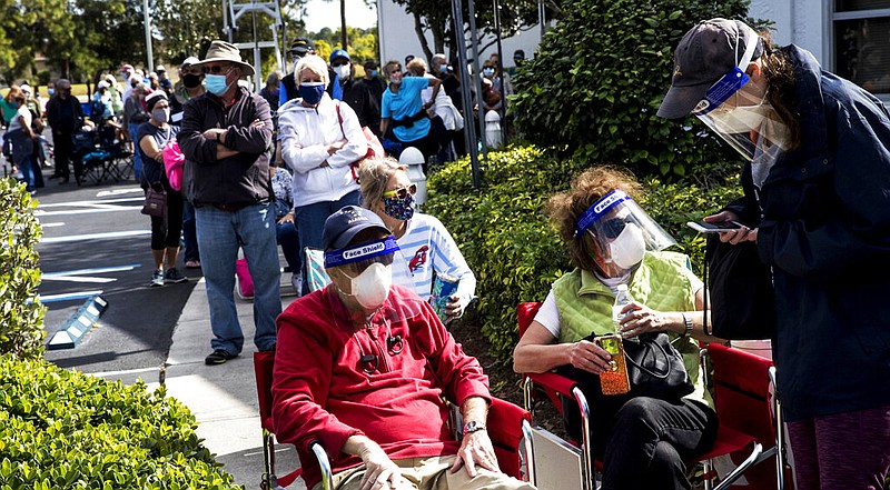 Joel and Susan Pittelman, from Naples, Fla., wait in line to receive COVID-19 vaccines on Tuesday, Dec. 29, 2020, at East County Regional Library in Lehigh Acres, Fla. (Andrew West /The News-Press via AP)