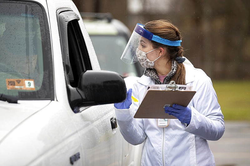 Registered nurse Carrie Perry records information from a driver in Wayne, W.Va., on Thursday, Dec. 31, 2020. The Wayne County Health Department was offering covid-19 vaccines for anyone 80 years of age or older at a drive-thru site.