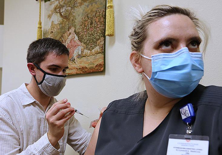 Pharmacist Daniel Cate, with Market Place Pharmacy, gives a covid-19 vaccination to certified nursing assistant Allysandra Hawkins on Tuesday at Stonehaven Assisted Living Center in Maumelle.
(Arkansas Democrat-Gazette/Thomas Metthe)