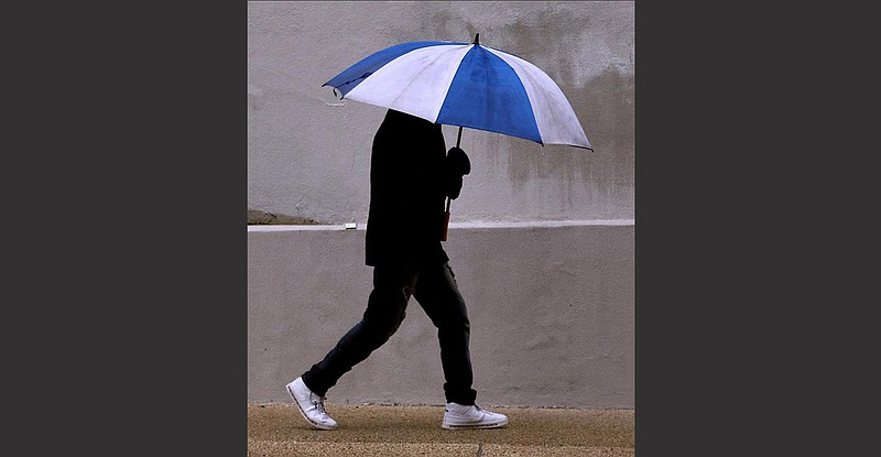 A man walks in a cold rain Thursday along West Capitol Avenue in Little Rock.
(Arkansas Democrat-Gazette/Thomas Metthe)