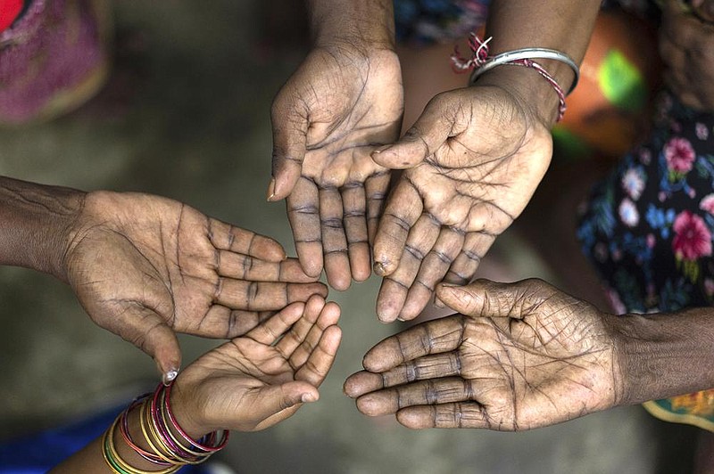 Women from age 6 to 102 in a family that has worked on a palm oil plantation in Malaysia for five generations hold out their hands in this file photo. The U.S. said it will ban all shipments of palm oil from one of the world’s biggest producers after finding indicators of forced labor and other abuses on plantations that feed into the supply chains of some of America’s most famous food and cosmetic companies.
(AP)
