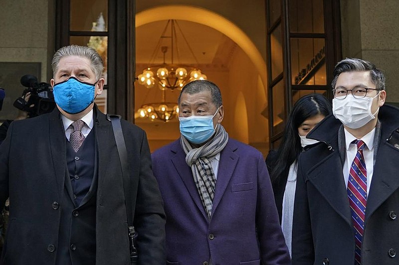 Hong Kong pro-democracy activist and media tycoon Jimmy Lai (center) leaves court Thursday during a break in his hearing. More photos at arkansasonline.com/11jimmylai/.
(AP/Kin Cheung)