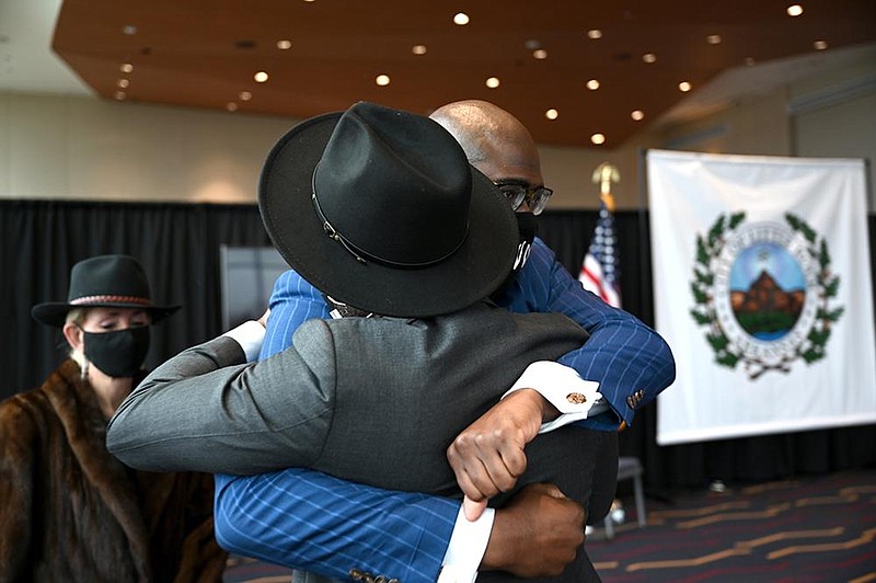 Little Rock Mayor Frank Scott Jr. hugs his friend Antwan Phillips (wearing hat) after Phillips was  sworn in Friday as a new city director. More photos at arkansasonline.com/12phillips/.
(Arkansas Democrat-Gazette/Stephen Swofford)