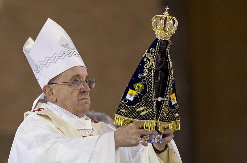 Pope Francis holds up the statue of the Virgin of Aparecida, Brazil's patron saint, during Mass in the Aparecida Basilica in Aparecida, Brazil, Wednesday, July 24, 2013. 
(AP Photo/Felipe Dana)