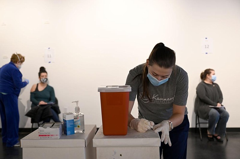 Mackenzie Reinhart, a third-year pharmacy student at UAMS, helps administer covid-19 vaccines to patients on Saturday, Jan. 2, 2021. (Arkansas Democrat-Gazette/Stephen Swofford)