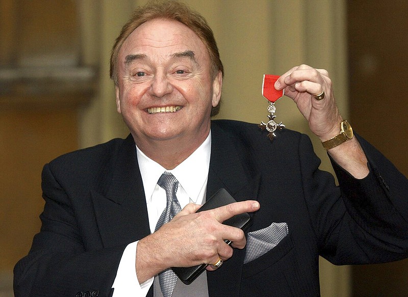 Gerry Marsden holds his medal signaling that he is a member of the Most Excellent Order of the British Empire in this Dec. 12, 2003, file photo. Marsden, the lead singer of Gerry and the Pacemakers, has died. He was 78.