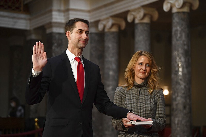 U.S. Sen. Tom Cotton, R-Ark., takes the oath of office as his wife, Anna Peckham, holds a Bible during a reenactment ceremony in the Old Senate Chamber at the Capitol in Washington on Sunday, Jan. 3, 2021.