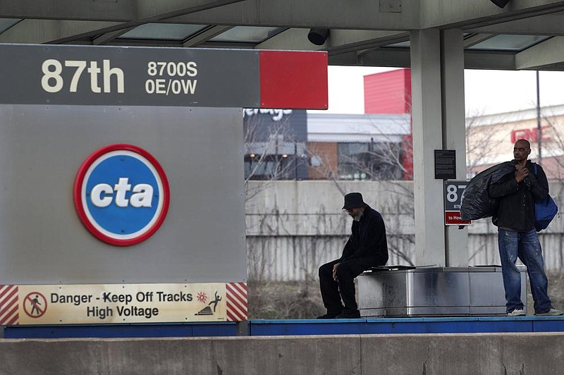 Men wait for a Chicago Transit Authority Red Line train on Chi- cago’s South Side in this April file photo. Bedford Park, a hub for manufacturing employers just outside the Chicago city limits, has started a pilot program to help employees commute to work. (AP)