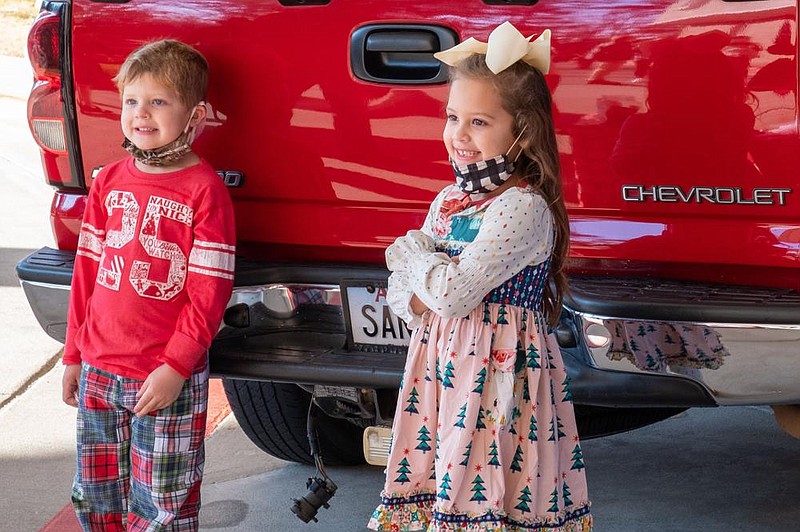 Mikah and Emmalynn Boschetti stand by Santa’s truck.