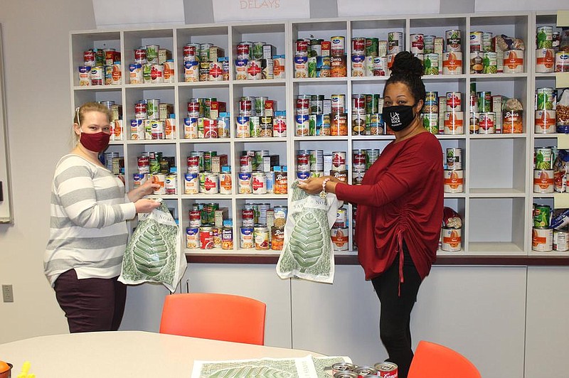 Rosalie Shahan and Katresha Bell select canned goods for Helping Hands.