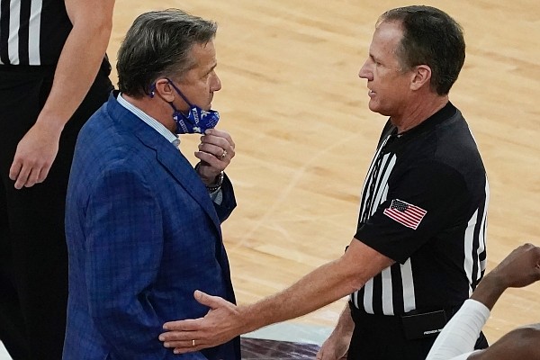 Kentucky head coach John Calipari, left, confers with an official after being tossed out of an NCAA college basketball game against Mississippi State during the second half in Starkville, Miss., Saturday, Jan. 2, 2021. (AP Photo/Rogelio V. Solis)