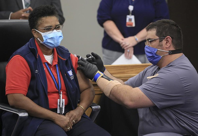 Nurse Charles Brenke (right), with Wellpath, the Department of Corrections’ contracted medical pro- vider, gives the P zer covid-19 vaccine to Department of Corrections Capt. Dwana Johnson on Tuesday in North Little Rock.
(Arkansas Democrat-Gazette/Staton Breidenthal)