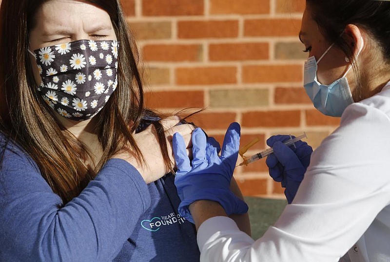 Veronica Harden, R.N. Supervisor at the Arkansas State Veterans Home at Fayetteville, receives a covid-19 vaccine shot Tuesday, January 5, 2021, from Falon Lacey, a pharmacist with AllCare Pharmacy, in front of the home in Fayetteville. The first round of vaccinations were given to residents and staff in Fayetteville and at the facility in North Little Rock that both provide long-term care and short-term rehabilitation. Check out nwaonline.com/210106Daily/ and nwadg.com/photos for a photo gallery.
(NWA Democrat-Gazette/David Gottschalk)