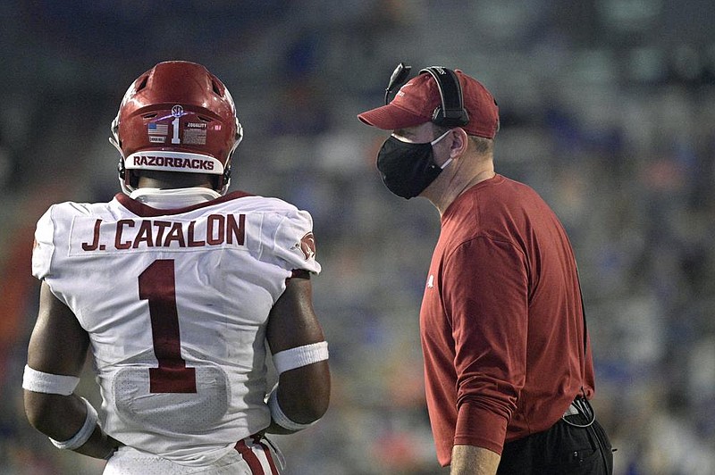 Acting Arkansas head coach Barry Odom, right, talks to defensive back Jalen Catalon (1) during the second half of an NCAA college football game against Florida, Saturday, Nov. 14, 2020, in Gainesville, Fla. (AP Photo/Phelan M. Ebenhack)