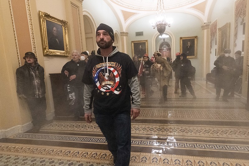 Smoke fills the walkway outside the Senate Chamber as supporters of President Donald Trump are confronted by U.S. Capitol Police officers inside the Capitol, Wednesday, Jan. 6, 2021 in Washington. (AP Photo/Manuel Balce Ceneta)