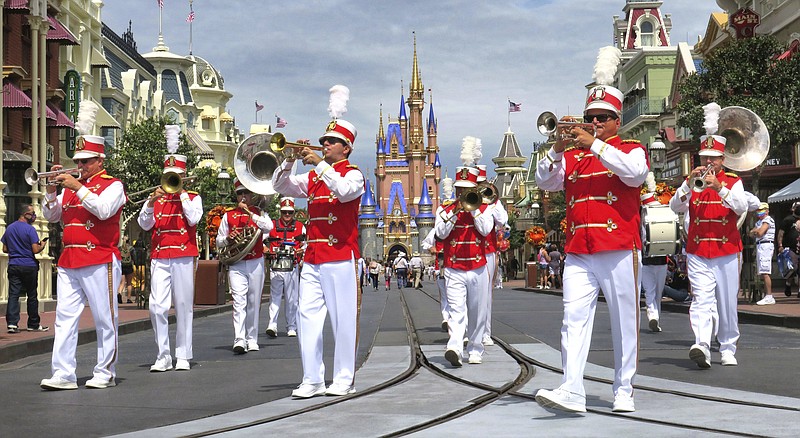 The Main Street Philharmonic marching band performs in the Magic Kingdom at Walt Disney World. Disney will mark the 50th anniversary of the Florida resort on Oct. 1, but visitors should expect pandemic-driven changes. (Democrat-Gazette file photo)