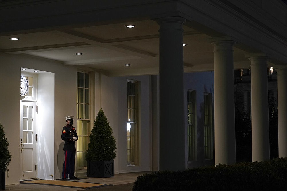 A Marine stands Thursday, Jan. 7, 2021, outside the entrance to the West Wing of the White House, signifying President Donald Trump is in the Oval Office in Washington.