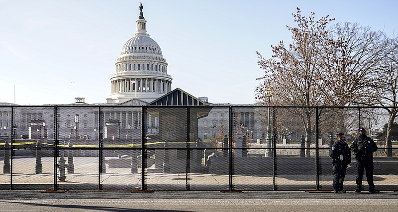 Capitol police officers stand outside of fencing that was installed around the exterior of the Capitol grounds, Thursday, Jan. 7, 2021 in Washington. The House and Senate certified the Democrat’s electoral college win early Thursday after a violent throng of pro-Trump rioters spent hours Wednesday running rampant through the Capitol. A woman was fatally shot, windows were bashed and the mob forced shaken lawmakers and aides to flee the building, shielded by Capitol Police. story.lead_photo.caption