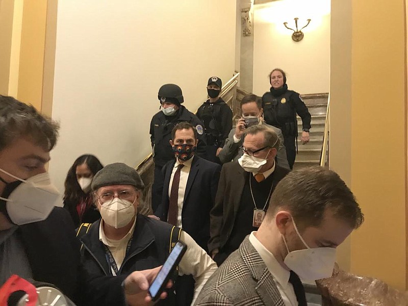 People are escorted out of the House chamber Wednesday after protesters stormed the building. From there, many in the building entered the tunnels beneath the building to find refuge.
(Arkansas Democrat-Gazette/Frank Lockwood)