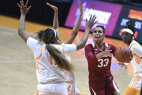 Arkansas' Chelsea Dungee (33) scores on a drive with Tennessee's Rae Burrell and Kasiyahna Kushkituah (11) defending during an NCAA college basketball game Thursday, Jan. 7, 2021, in Knoxville Tenn. (Scott Keller/The Daily Times via AP)