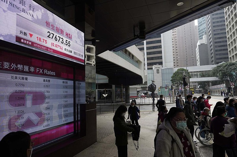 People walk past a bank’s electronic board Thursday showing the Hong Kong share index at the Hong Kong Stock Exchange.
(AP/Vincent Yu)